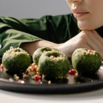 Close-up of spinach pkhali, a Georgian vegan dish, with a woman in green observing.